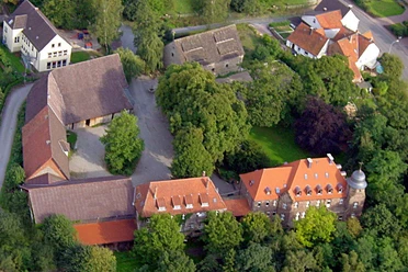 Burg Borgholz Luftbild der historischen Burg Borgholz mit umliegenden Gebäuden und dichtem Baumbestand.