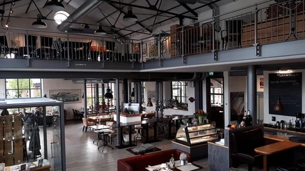 Gastraum Eisenhütte Guest room of a cozy restaurant with industrial flair: gallery level, seating areas and plenty of daylight.