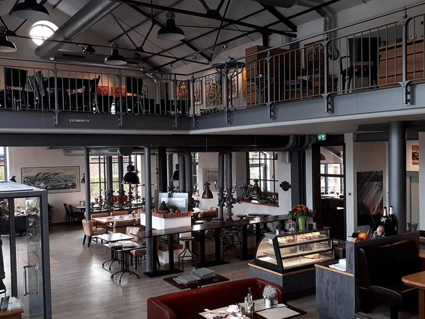 Gastraum Eisenhütte Gastraum eines gemütlichen Restaurants mit industriellem Flair: Galerieebene, Sitzbereiche und viel Tageslicht.
