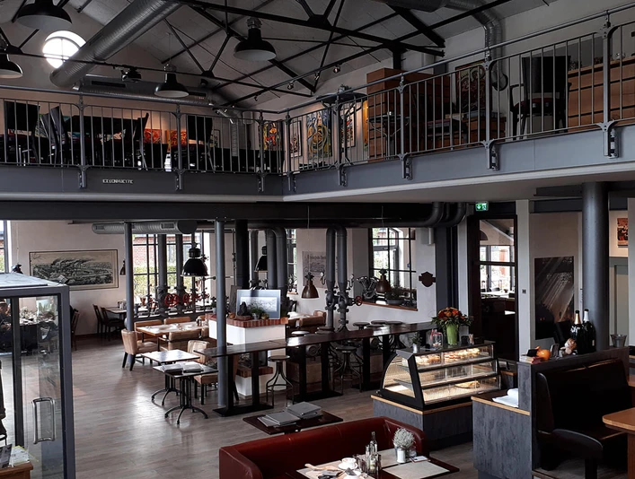 Gastraum Eisenhütte Gastraum eines gemütlichen Restaurants mit industriellem Flair: Galerieebene, Sitzbereiche und viel Tageslicht.