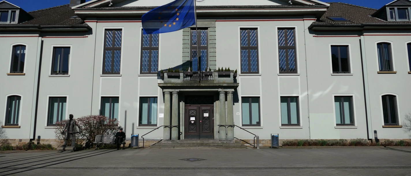 Rathaus in Heiligenhaus Das historische Rathaus in Heiligenhaus mit EU-Flagge und schmuckvoller Fassade bei Sonnenschein.
