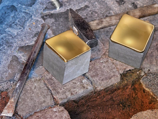 Zwei glänzende Stolpersteine aus Messing liegen auf einem historischen, gepflasterten Gehweg.
