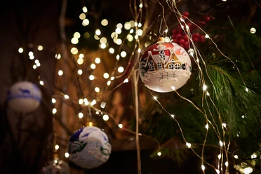 Weihnachtskugeln Eine stimmungsvolle Weihnachtsdekoration mit glitzernden Lichtern und festlich bemalten Kugeln.