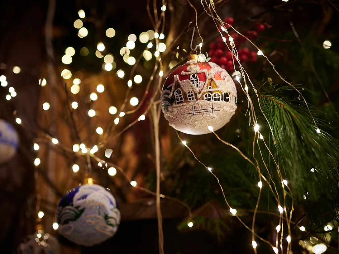 Weihnachtskugeln Eine stimmungsvolle Weihnachtsdekoration mit glitzernden Lichtern und festlich bemalten Kugeln.An atmospheric Christmas decoration with twinkling lights and festively painted baubles.