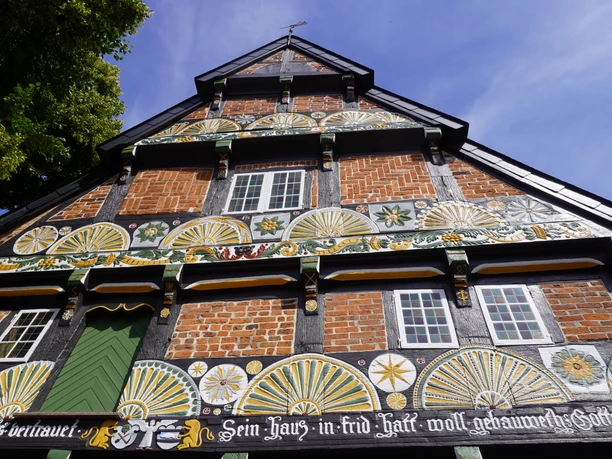 Historic farmhouse with rich wood carvings and half-timbering in bright colors.