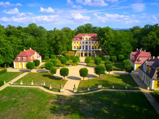 Baroque Neschwitz Castle with symmetrical gardens surrounded by forest.