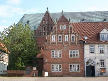 Dom Verden Historischer Backsteinbau mit Staffelgiebel vor einer großen gotischen Kirche unter blauem Himmel.Historic brick building with stepped gable in front of a large Gothic church under a blue sky.Historisk murstensbygning med trappegavl foran en stor gotisk kirke under en blå himmel.Historisch bakstenen gebouw met trapgevel voor een grote gotische kerk onder een blauwe hemel.