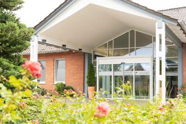 Krankenhaus Land Hadeln Otterndorf Blühende Rosen vor dem modernen, barrierefreien Eingang des Krankenhauses Land Hadeln.