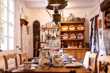 Alte Küche mit Geschirr, Töpfen, traditionellem Charme und blauen Dekorelementen im Landhausstil.