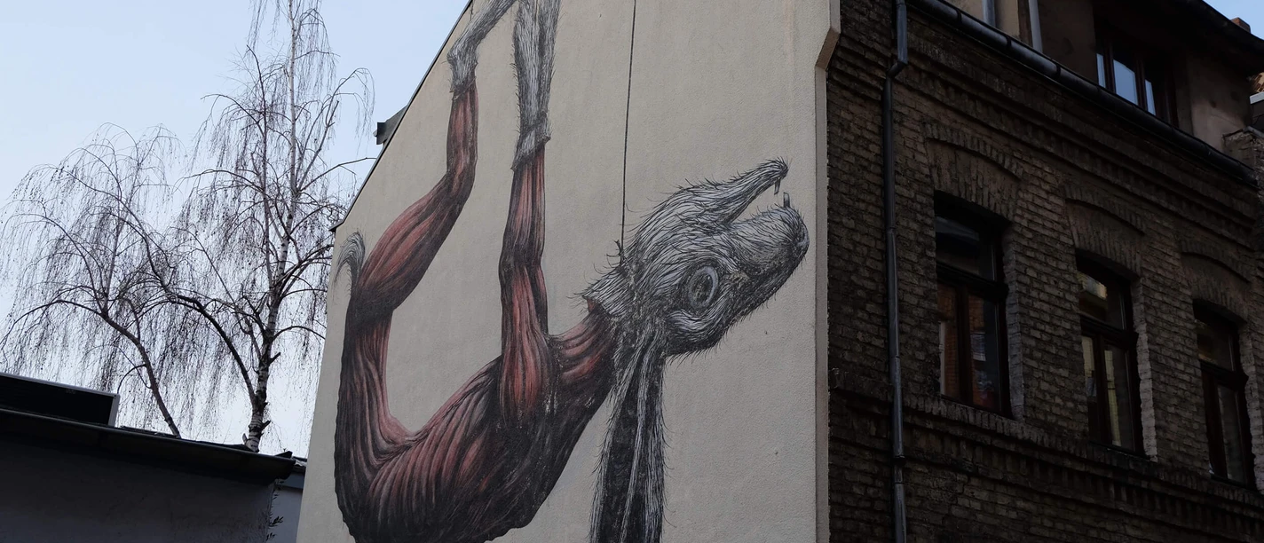 Mural An impressive mural depicts a large rabbit hanging on a wall in great detail, giving the building façade a unique touch.