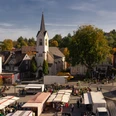 Marktplatz Wipperfürths idyllischer Marktplatz mit historischen Gebäuden und St. Nikolaus Kirche, Marktstände im Vordergrund.