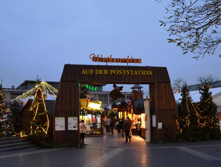 Weihnachtsmarkt in Langenfeld Weihnachtsmarkt-Eingang aus Holz mit Lichtern, Tannengirlanden und festlichem Schriftzug.