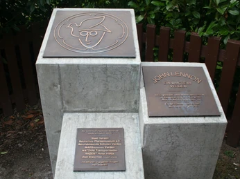 John Lennon-Denkmal Verden John Lennon-Denkmal in Verden aus hellgrauem Stein mit Bronzetafeln und stilisiertem Porträt des Musikers.