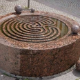 Der Gezeitenbrunnen in Verden ist ein runder, spiralförmiger Brunnen aus rötlichem Granit mit Kugeln.