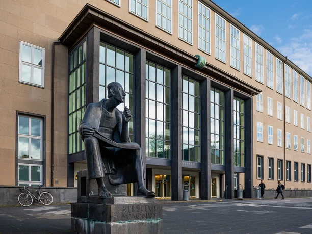 Albertus Magnus Monument The Albertus Magnus monument, a bronze statue of the seated scholar, in front of a modern building in Cologne.