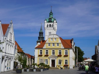 Rathaus Verden Historisches Rathaus Verden mit gelber Fassade, markantem Uhrenturm und roten Ziegeldächern.