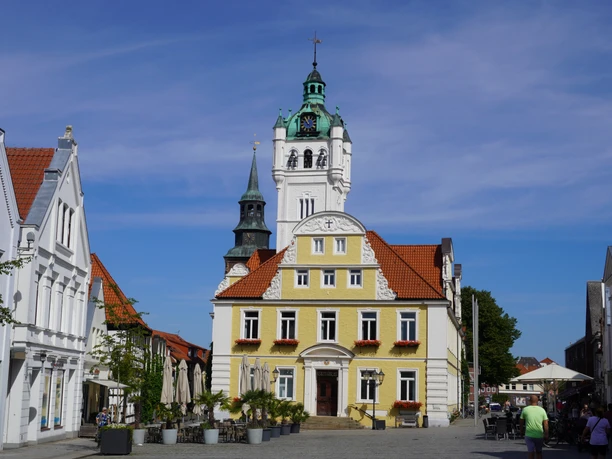 Rathaus Verden Historisches Rathaus Verden mit gelber Fassade, markantem Uhrenturm und roten Ziegeldächern.