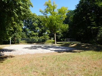 Ein Volleyballfeld im Bürgerpark Verden, umgeben von üppigen, grünen Bäumen und Freiflächen.