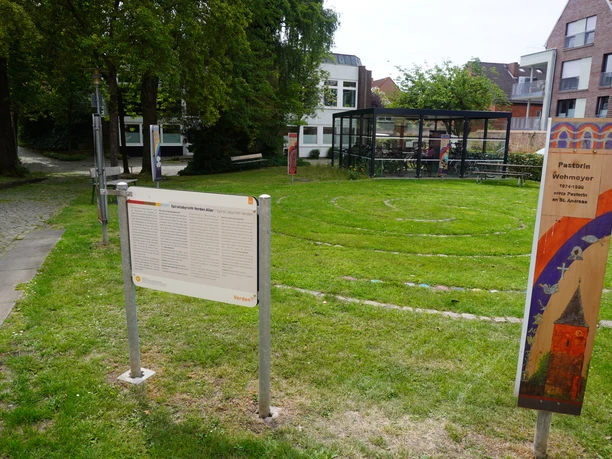 Eingebettet in eine grüne Rasenfläche, unwinden sich sanfte Steinkreise neben einem modernen Glasgebäude.