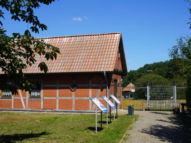 Storchenpflegestation Verden Storchenpflegestation in Verden mit Fachwerkgebäude, Infotafeln und grünem Umfeld unter blauem Himmel.