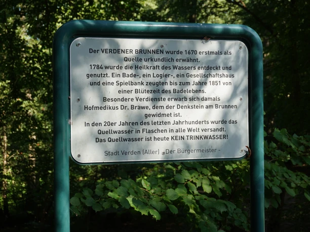 Brunnen Verden Eine grüne Infotafel im dichten Wald beschreibt die Geschichte des Verdener Brunnens ausführlich.