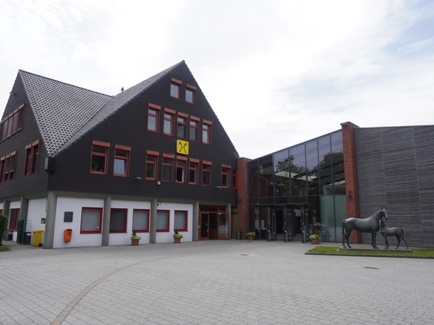 Niedersachsenhalle Verden Niedersachsenhalle Verden mit modernem Anbau und Pferdestatue im Vordergrund unter bewölktem Himmel.