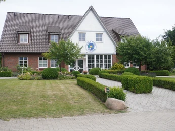 Golfplatz Verden Backsteinbau mit gepflegtem Garten vor dem Eingang des Golfplatzes Verden unter grauem Himmel.Brick building with well-tended garden in front of the entrance to the Verden golf course under a gray sky.Murstensbygning med velplejet have foran indgangen til golfbanen i Verden under en grå himmel.Bakstenen gebouw met verzorgde tuin voor de ingang van de golfbaan van Verden onder een grijze hemel.