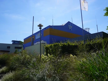Ein modernes Freizeit- und Erlebnisbad mit markanten blauen und gelben Architekturelementen.