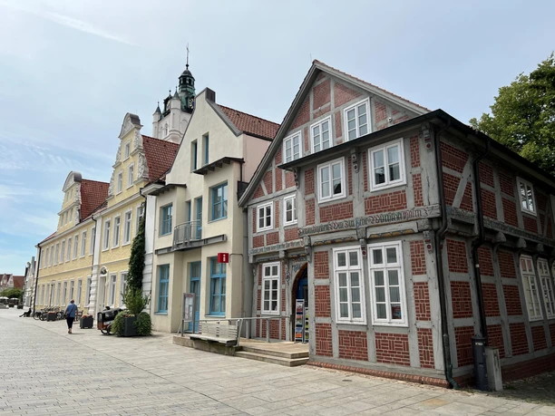 Historic, colorful facades line a quiet street in Verden, including the tourist information office.
