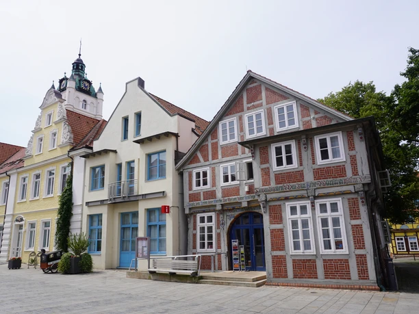 Tourist information office in Verden in front of historic buildings with red and white half-timbering and a yellow façade.