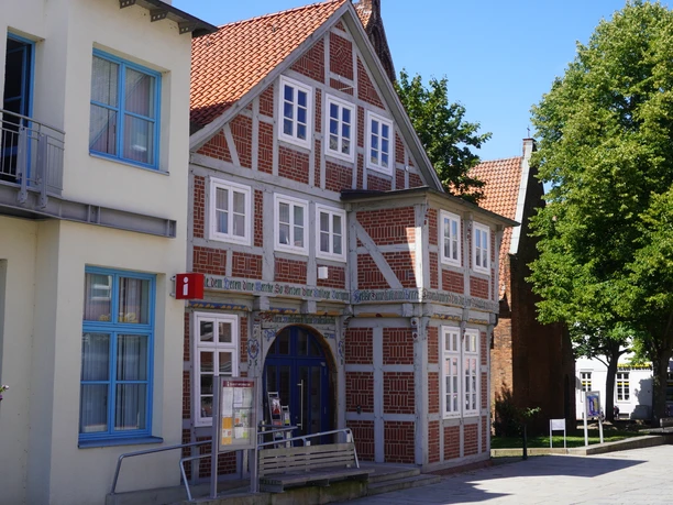 The Verden Tourist Information Office is housed in a historic half-timbered building surrounded by trees.