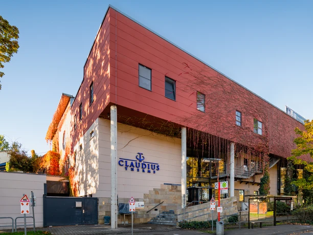 Claudius Thermal Baths Außenansicht der Claudius-Therme in Köln, ein modernes Gebäude mit roten und weißen Fassaden.