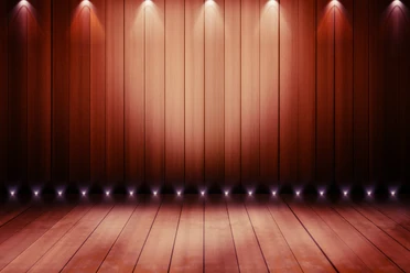 Holzboden und Holzwand mit sanfter Beleuchtung in warmen Erdtönen auf einer Theaterbühne.