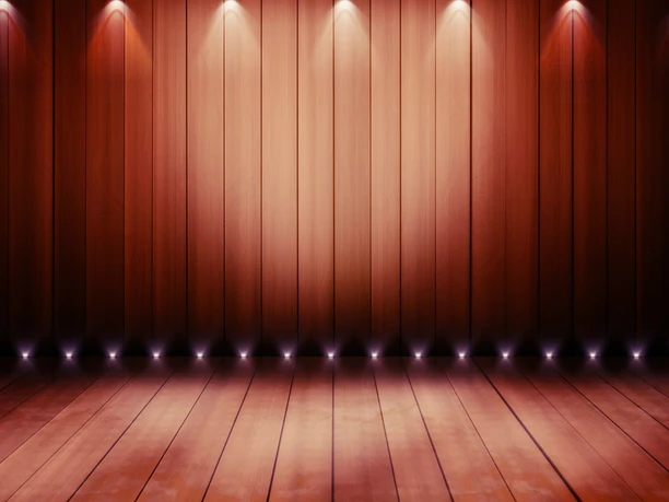 Holzboden und Holzwand mit sanfter Beleuchtung in warmen Erdtönen auf einer Theaterbühne.