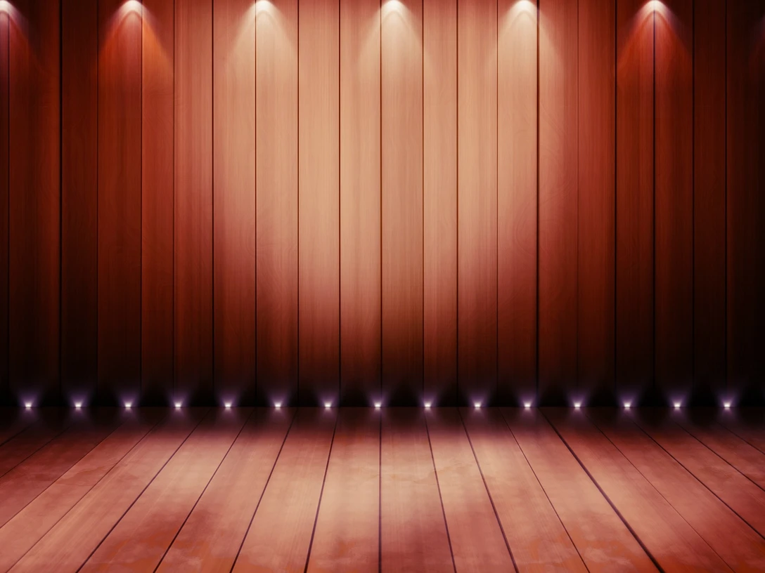 Theaterbühne Holzboden und Holzwand mit sanfter Beleuchtung in warmen Erdtönen auf einer Theaterbühne.