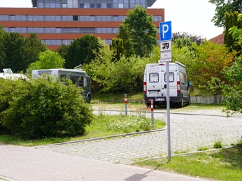 Wohnmobilstellplatz Verden Wohnmobilstellplatz in Verden mit gepflastertem Untergrund, von Bäumen umgeben und Parkplatzschild.