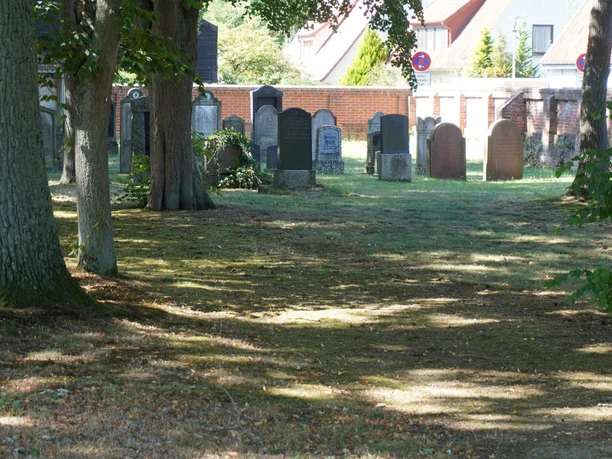 Jüdischer Friedhof Verden mit alten Grabsteinen, umgeben von Bäumen, in ruhiger, grüner Umgebung.