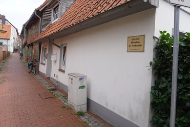 In der Altstadt von Verden steht ein historisches Hirtenhaus, gekennzeichnet mit einer Infotafel.
