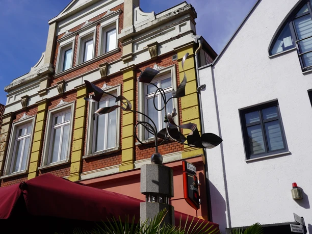 Wachstumssäule Moderne Kunstinstallation "Wachstumssäule" vor historischem Gebäude mit markanten Fenstern und Geländer.