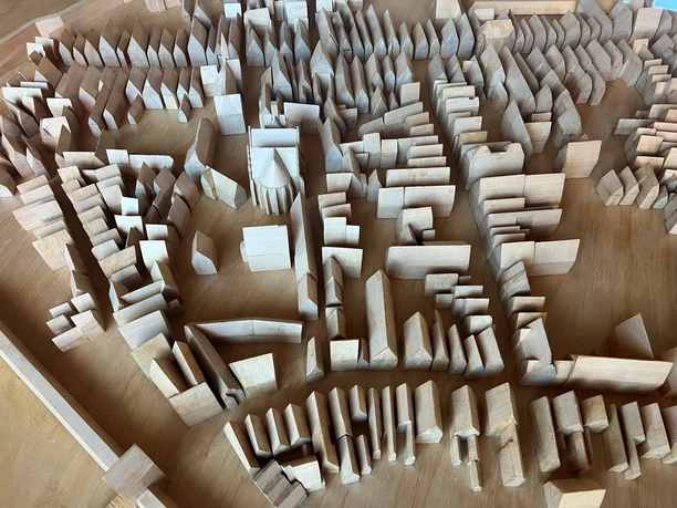 Stadtmodell im Rathaus Detailliertes Holzschnittmodell einer Stadtlandschaft mit Gebäudestrukturen und Straßenanordnung.