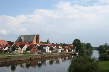 Reiterstadt Verden Verden mit historischer Architektur entlang der Aller, eingerahmt von üppigem Grün und sanftem Fluss.