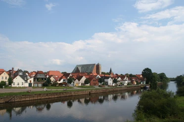 Blick auf Verden mit der gotischen Domkirche, umgeben von kleinen Häusern am Ufer der Aller.