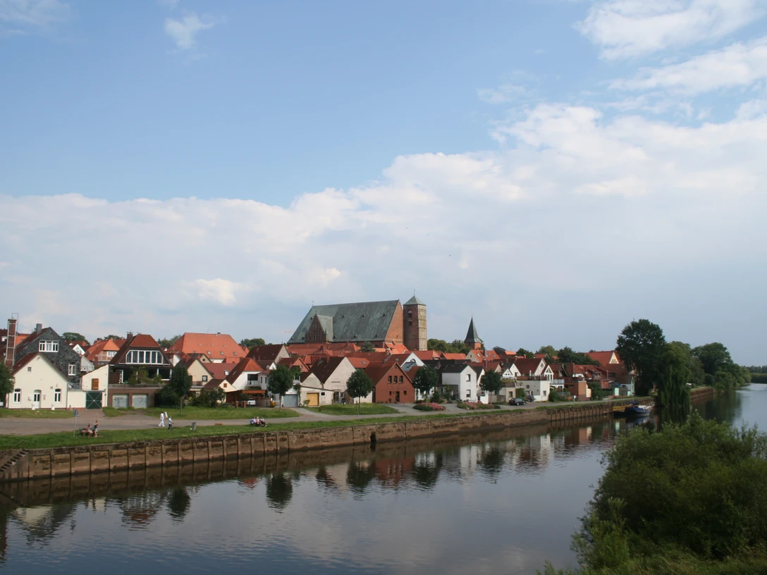 Reiterstadt Verden Blick auf Verden mit der gotischen Domkirche, umgeben von kleinen Häusern am Ufer der Aller.