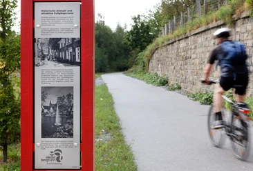 Infotafel über Wülfrath am PanoramaRadweg niederbergbahn Eine Infotafel am PanoramaRadweg Niederbergbahn mit Infos zur historischen Altstadt von Wülfrath.