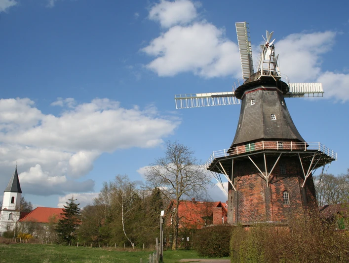 Fehsenfeldsche Mühle Martfeld Fehsenfeldsche Mühle Martfeld: Historische Holländerwindmühle, flankiert von Kirche und Natur.