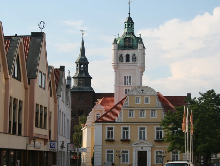 Rathaus Verden Historisches Rathaus von Verden mit weißem Turm und Uhr, umgeben von Fachwerkhäusern und Bäumen.