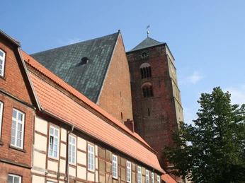 Dom Verden Backsteingotische Architektur des Dom Verdens mit beeindruckendem Turm vor blauem Himmel und Fachwerkhäusern.