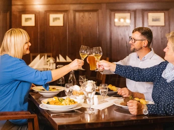 Getting together at Auerbachs Keller Restaurant – Leipzig Cuisine Drei Gäste in Auerbachs Keller stoßen bei gedecktem Tisch mit ihren Wein- oder Biergläsern anThree visitors to Auerbachs Keller Restaurant raise a toast with their wine and beer glassesTrois invités de l'Auerbachs Keller trinquent avec leurs verres de vin ou de bière devant une table bien garnieTrójka gości przy nakrytym stole w Auerbachs Keller stuka się lampkami z winem czy szklankami z piwemTři hosté si v Auerbachově sklepě připíjí u prostřeného stolu číškami s vínem nebo sklenicemi s pivem