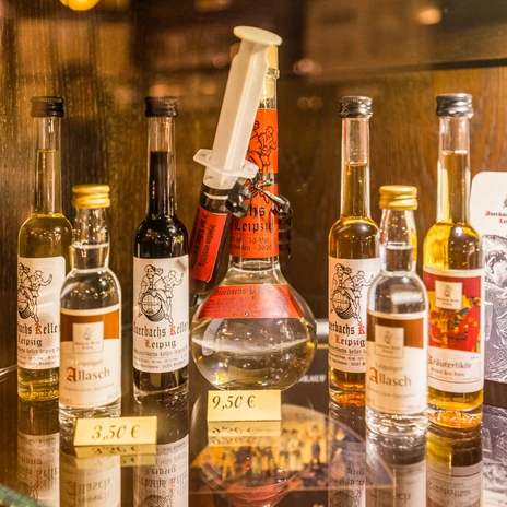 Widok szklanych butelek pełnych typowych lipskich alkoholi, gastronomia, kulinarne przysmaki