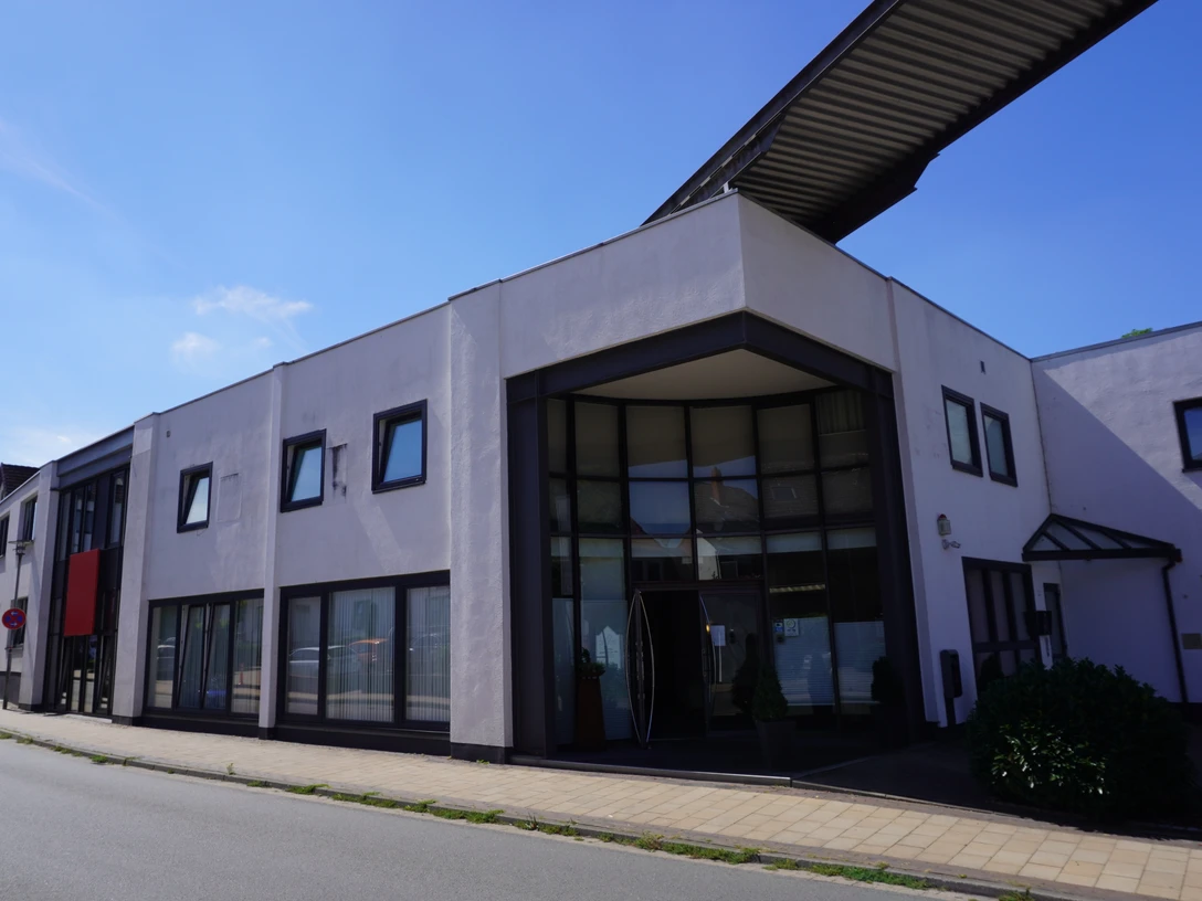 Thöles Hotel (2).JPG Modernes Hotelgebäude mit großflächigen Fenstern und einem winkeligen Eingangsbereich an der Straße.